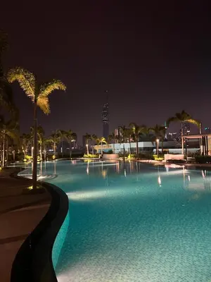 a large swimming pool with palm trees at night at Skyscraper 65 KL Highest Outdoor Bathtub Luxury Lavish Designer Suite Penthouse Lv65 in Kuala Lumpur