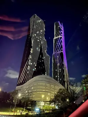 two tall buildings are lit up at night at Simple Arte Mont Kiara 1B1B 4 Pax Mitec Matrade in Kuala Lumpur