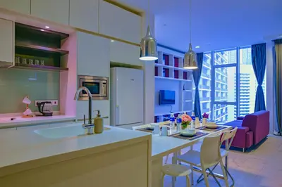 a kitchen with a sink and a living room at SKYWARD SUITES at Platinum KLCC in Kuala Lumpur