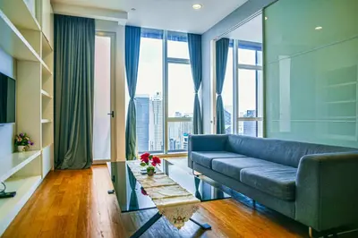 a living room with a couch and a large window at SKYWARD SUITES at Platinum KLCC in Kuala Lumpur