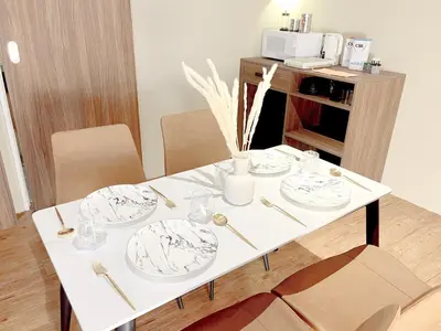 a white table with plates and vases on it at The Bourke - Bangsar Trade Centre in Kuala Lumpur