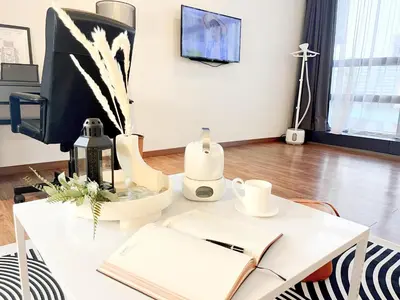 a white desk with a computer and a book at The Collins - Bangsar Trade Centre in Kuala Lumpur