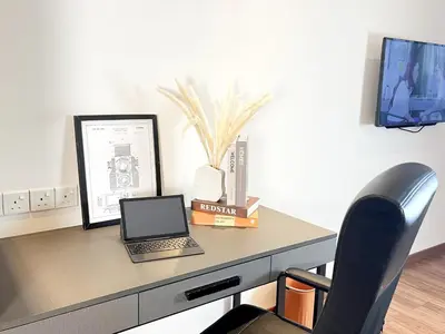 a desk with a laptop computer on top of it at The Collins - Bangsar Trade Centre in Kuala Lumpur