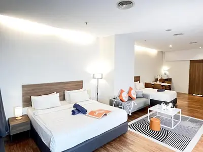 a hotel room with two beds and a couch at The Collins - Bangsar Trade Centre in Kuala Lumpur