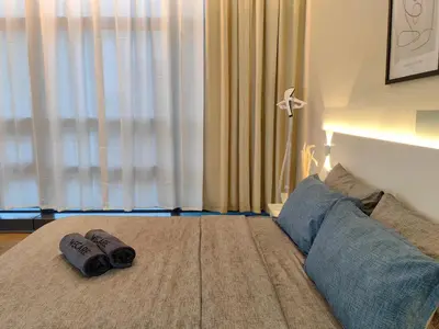 a bedroom with two slippers on a bed with a window at The Tranquil - Bangsar Trade Centre in Kuala Lumpur