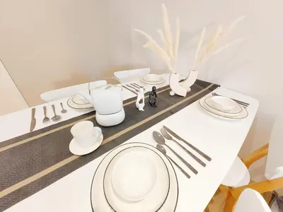 a table with white plates and utensils on it at The Ovation - Bangsar Trade Centre in Kuala Lumpur