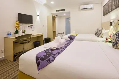 a hotel room with a large bed and a desk at Hotel Bintang Kuala Lumpur in Kuala Lumpur