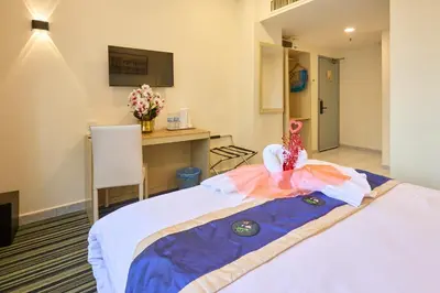 a room with a bed and a desk with flowers on it at Hotel Bintang Kuala Lumpur in Kuala Lumpur