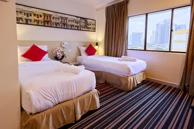 a hotel room with two beds and a window at Hotel Bintang Kuala Lumpur in Kuala Lumpur