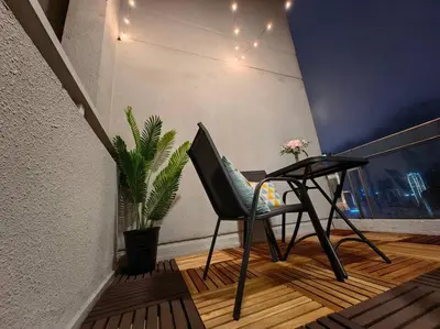a chair on a balcony with a table and a plant at MyCrib19*The Robertson KL - Bukit Bintang Pavilion in Kuala Lumpur