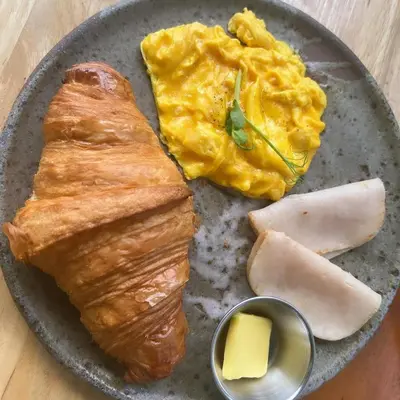 a plate of food with eggs and bread and cheese at Societe Hartamas in Kuala Lumpur