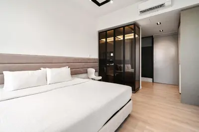 a bedroom with a large white bed and a chair at Expressionz Kuala Lumpur in Kuala Lumpur