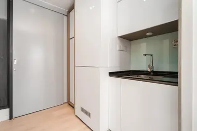a white kitchen with a sink and a refrigerator at Expressionz Kuala Lumpur in Kuala Lumpur