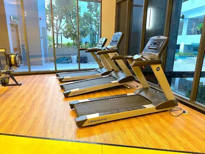 a row of treadmills in a gym with windows at Neu Suites By Serenity Homes Near Gleneagles, KLCC & LRT in Kuala Lumpur