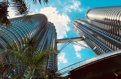 a tall building with a palm tree in front of it at Neu Suites By Serenity Homes Near Gleneagles, KLCC & LRT in Kuala Lumpur
