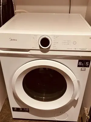 a white microwave oven sitting on top of a washing machine at Scarletz Suites Klcc by Signature Apartment in Kuala Lumpur