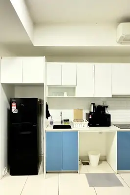 a kitchen with a black refrigerator and white cabinets at The Home by Fidi @ Continew Residence (Near TREC) in Kuala Lumpur