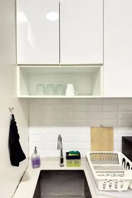 a kitchen with white cabinets and a sink at The Home by Fidi @ Continew Residence (Near TREC) in Kuala Lumpur