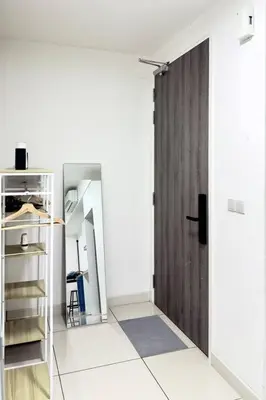 a room with a wooden door in a room with white walls at The Home by Fidi @ Continew Residence (Near TREC) in Kuala Lumpur