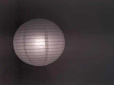 a white paper lantern hanging from a wall at Quill Residence by Cozy Simple Stay in Kuala Lumpur