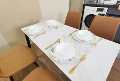 a dining room table with plates and glasses on it at The Sandstone - Bangsar Trade Centre in Kuala Lumpur