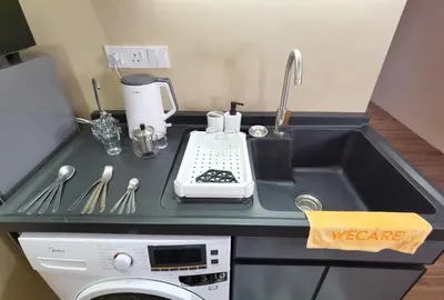 a kitchen counter with a sink and a washing machine at The Sandstone - Bangsar Trade Centre in Kuala Lumpur