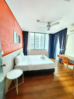 a bedroom with a bed and a desk and a table at Summer Suites KLCC By GRAND CENTRAL in Kuala Lumpur