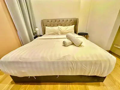 a bed with a phone sitting on top of it at Lucentia Global Signature Suites Kuala Lumpur in Kuala Lumpur