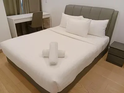 a bed with two towels on top of it at Lucentia Global Signature Suites Kuala Lumpur in Kuala Lumpur