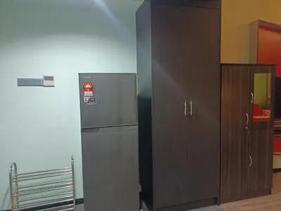 a kitchen with a refrigerator and a wooden cabinet at James' Studio unit Maison 101 at Heritage Row, Kuala Lumpur in Kuala Lumpur