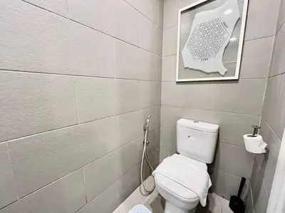 a bathroom with a toilet and a picture on the wall at 188 suites 2bedroom/4pax/13minute walk to klcc in Kuala Lumpur