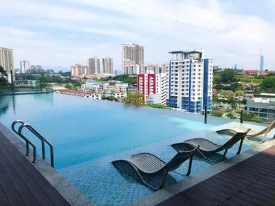 a large swimming pool with chairs on a building at M and S Suite at Societe Suites Sri Hartamas, Mont Kiara in Kuala Lumpur