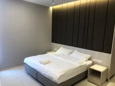 a bedroom with a white bed with a black headboard at M and S Suite at Societe Suites Sri Hartamas, Mont Kiara in Kuala Lumpur