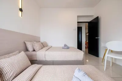 a bedroom with two beds and a table and a chair at RetroJazz Kids House 15pax 4Room in Kuala Lumpur
