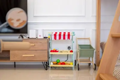 a toy kitchen with a table and a chair in a room at Kids Wonderland opposite MyTown near TRX Mall MRT in Kuala Lumpur