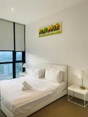 a bedroom with a large white bed with two tables at KL Sentral Bangsar Suites EST by Inam Suites in Kuala Lumpur