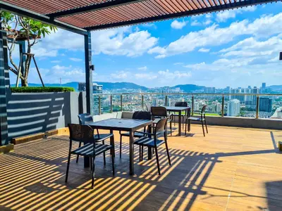 a patio with tables and chairs on a roof at Neu Suites by Snugster 2 Bedroom, 3km to KLCC in Kuala Lumpur