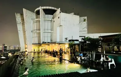 a pool in front of a building with people in it at Spritz Empire Regalia Suites & Residence in Kuala Lumpur