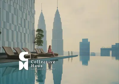 a woman sitting on a chair in front of the city at The Platinum 2 Kuala Lumpur By Collective Haus in Kuala Lumpur