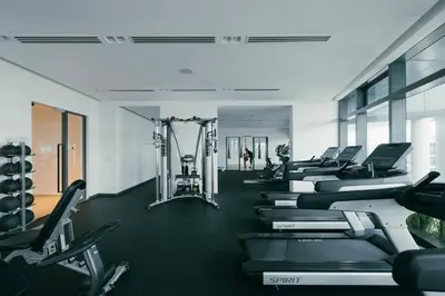 a gym with a row of treadmills and machines at NEW! Eaton Infinity SKY POOL KLCC view Pavilion in Kuala Lumpur