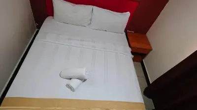 a white bed with a roll on it at Hotel Wings Kuala Lumpur in Kuala Lumpur