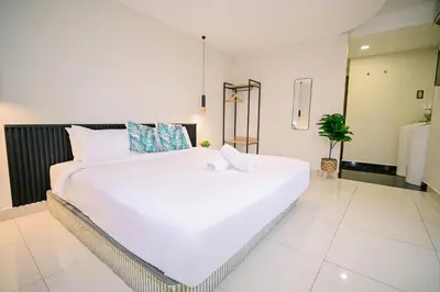 a large white bed in a large room at Swing & Pillows - Central Market Kuala Lumpur in Kuala Lumpur