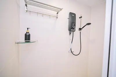 a bathroom with a shower with a blow dryer on the wall at Swing & Pillows - Central Market Kuala Lumpur in Kuala Lumpur