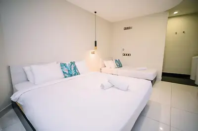 a white room with two beds and a couch at Swing & Pillows - Central Market Kuala Lumpur in Kuala Lumpur