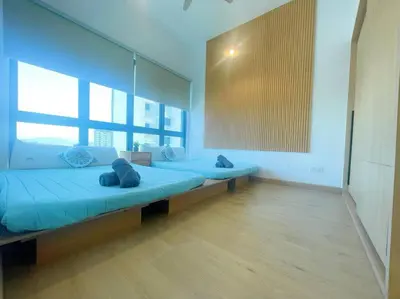 a large room with two beds with blue pillows at CL24A 5-6pax KLCC Sky Pool Condo in Kuala Lumpur