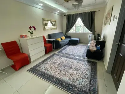 a living room with a blue couch and a red chair at Indah Putri Homestay in Kuala Lumpur