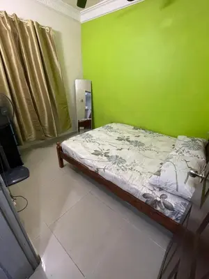 a bedroom with a bed with a green wall at Indah Putri Homestay in Kuala Lumpur