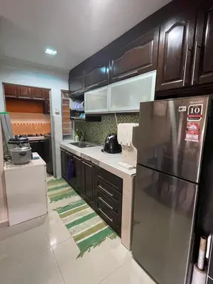 a kitchen with wooden cabinets and a stainless steel refrigerator at Indah Putri Homestay in Kuala Lumpur