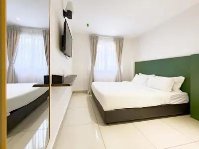 a hotel room with two beds and a television at Living At DSulaiman Hotel in Kuala Lumpur