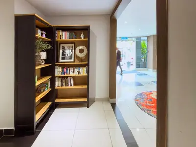 a hallway with book shelves and a person walking in the distance at Living At DSulaiman Hotel in Kuala Lumpur